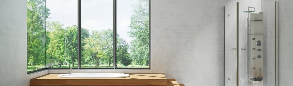 Badezimmer mit großer Fensterfront und Blick ins Grüne